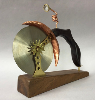 Handmade pizza cutter Rosewood handle with brass, copper & glass fittings in form of a single wheel bike with lamp; Koa wood stand. 1905