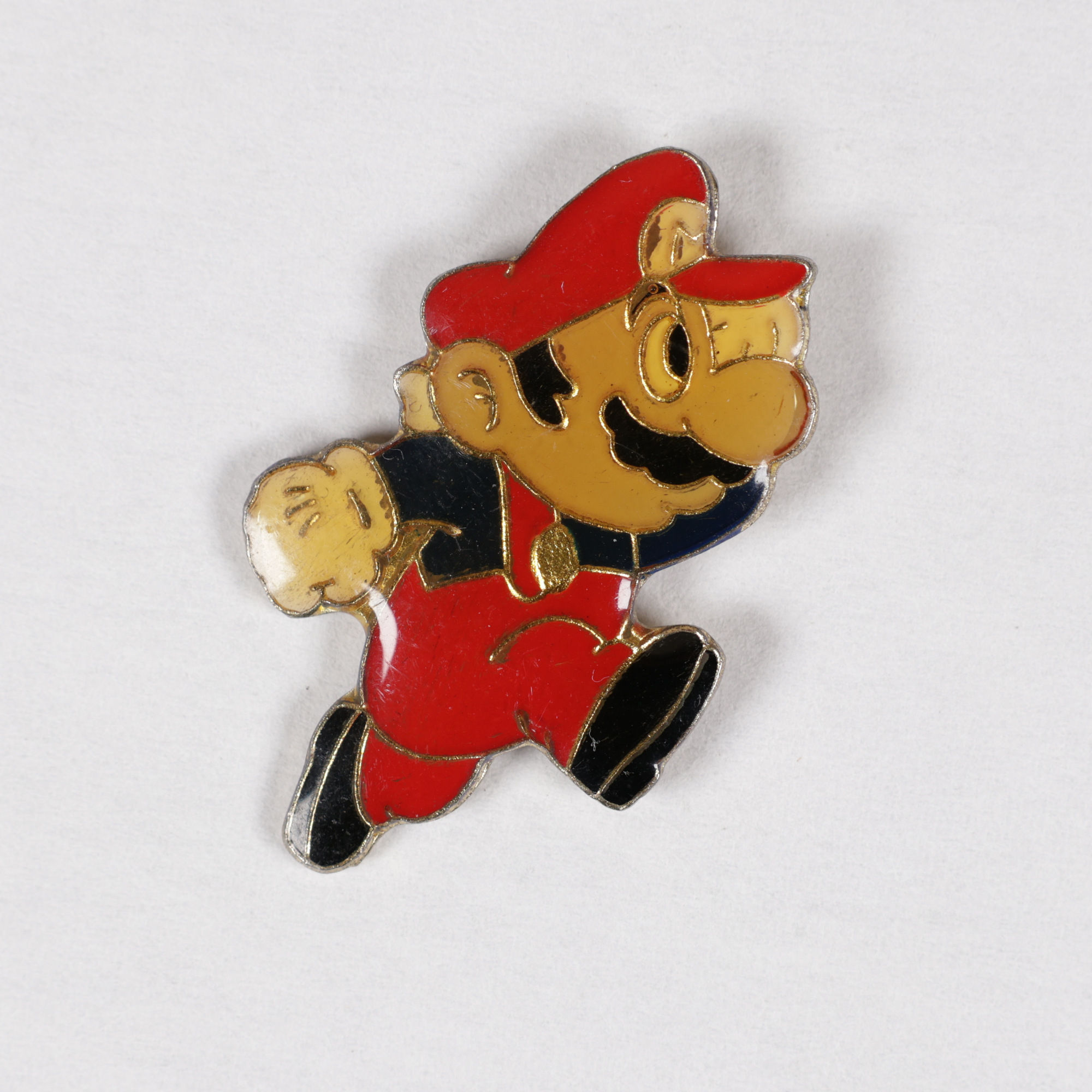 Pin's en métal émaillé représentant Super Mario en pleine course, vêtu de sa célèbre salopette rouge, de sa casquette rouge