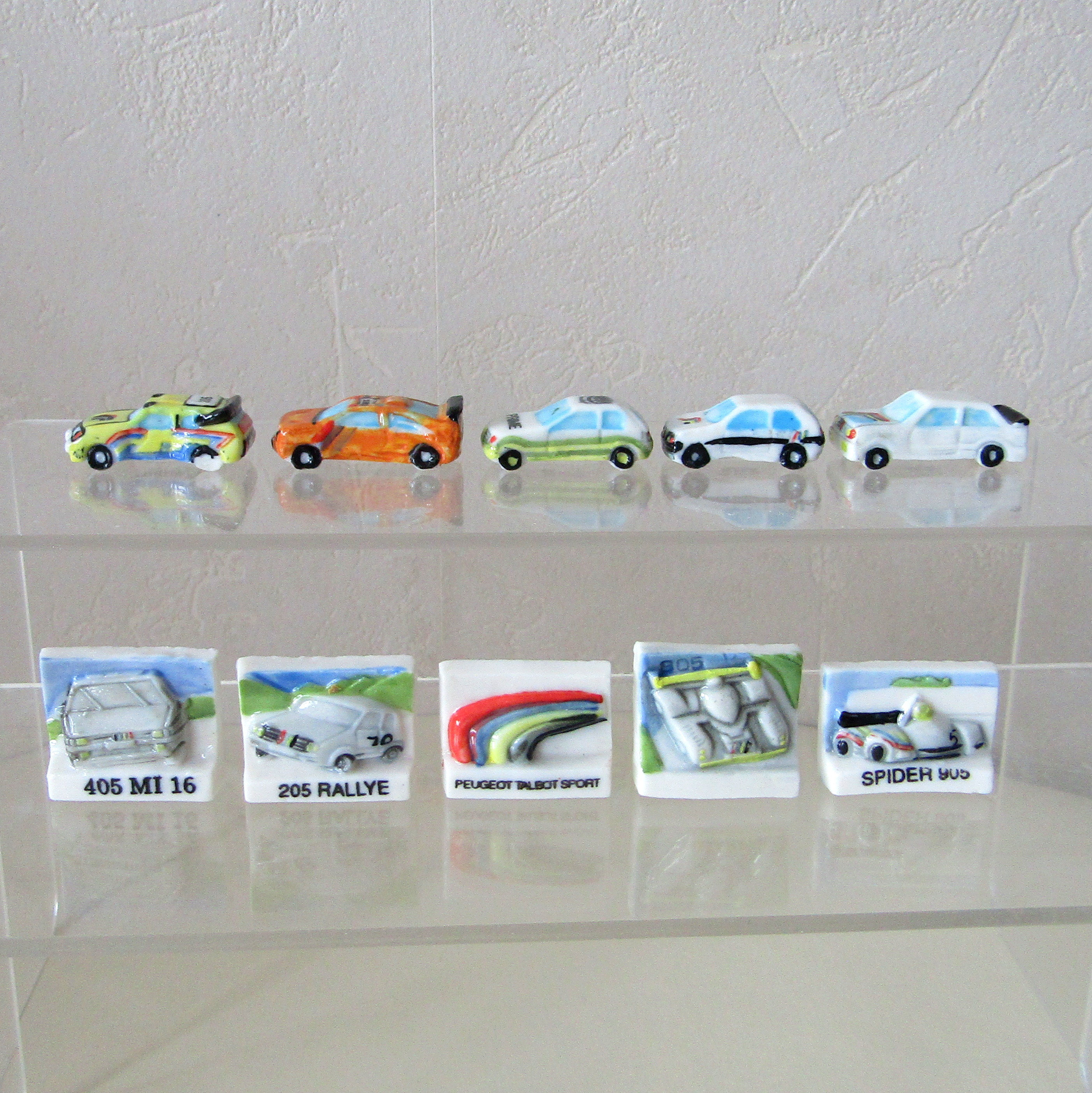 Série de 10 fèves brillantes en porcelaine « Roule galette Peugeot » éditée par Prime en 1994, représentant des modèles