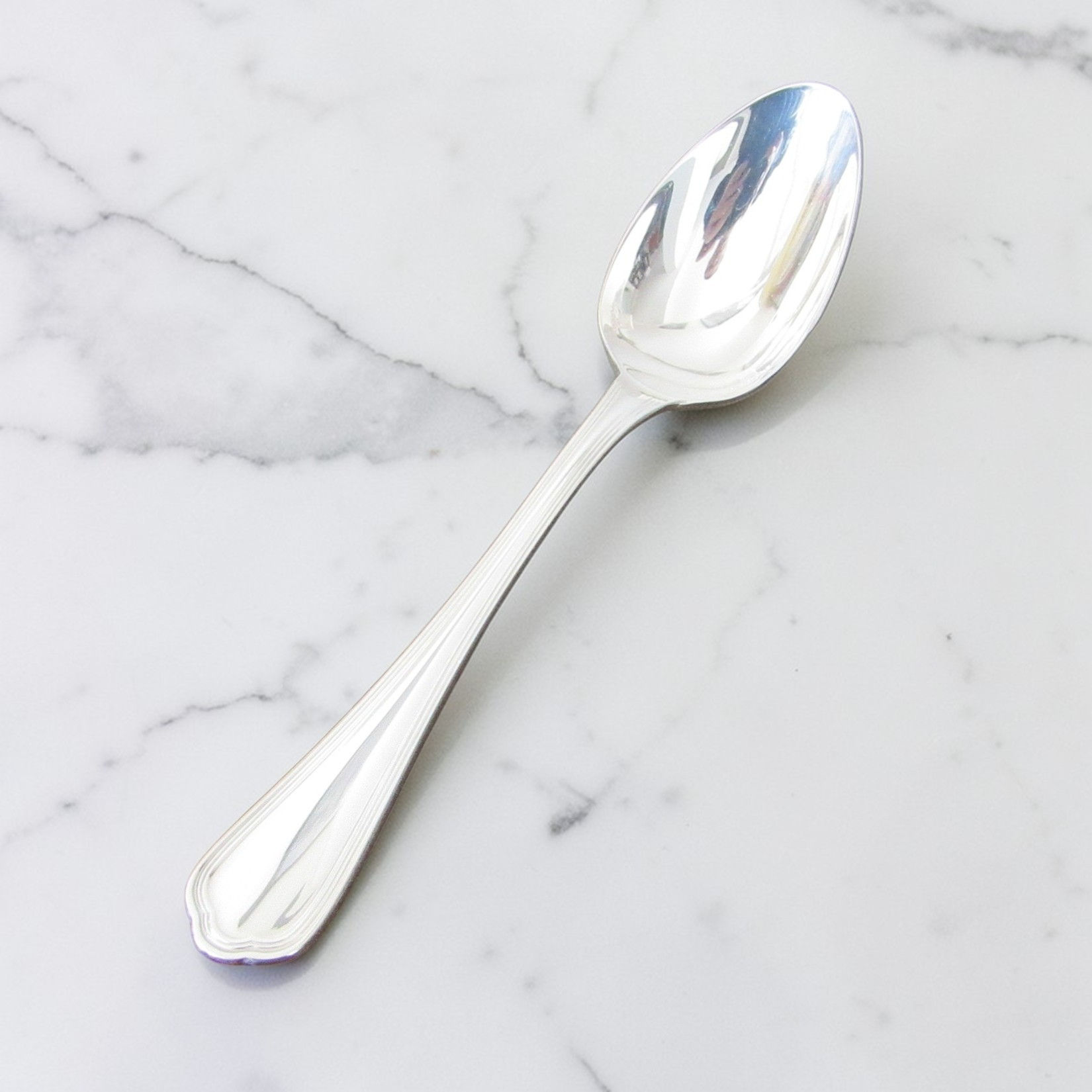 Cuillère à espresso Christofle modèle Spatours en métal argenté, longueur 10 cm, manche spatulé avec fines moulures et motif