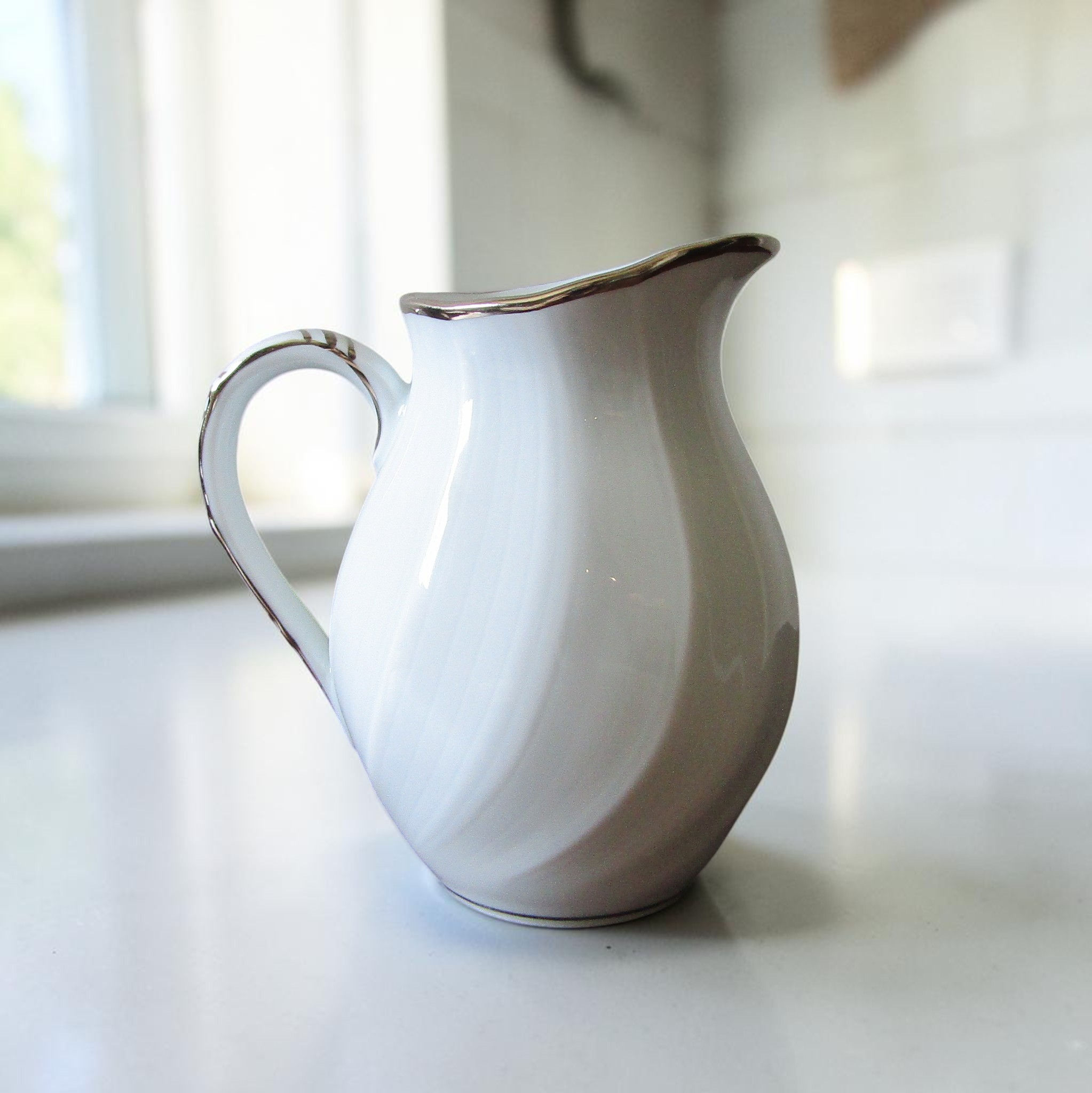 Pot à lait en porcelaine de Limoges Bernardaud modèle Verdi blanc avec reliefs ondulés et liseré argenté élégant.
