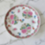 Plat rond en porcelaine de Limoges Raynaud modèle Compagnie des Indes Tétard avec décor floral polychrome et frise décorative