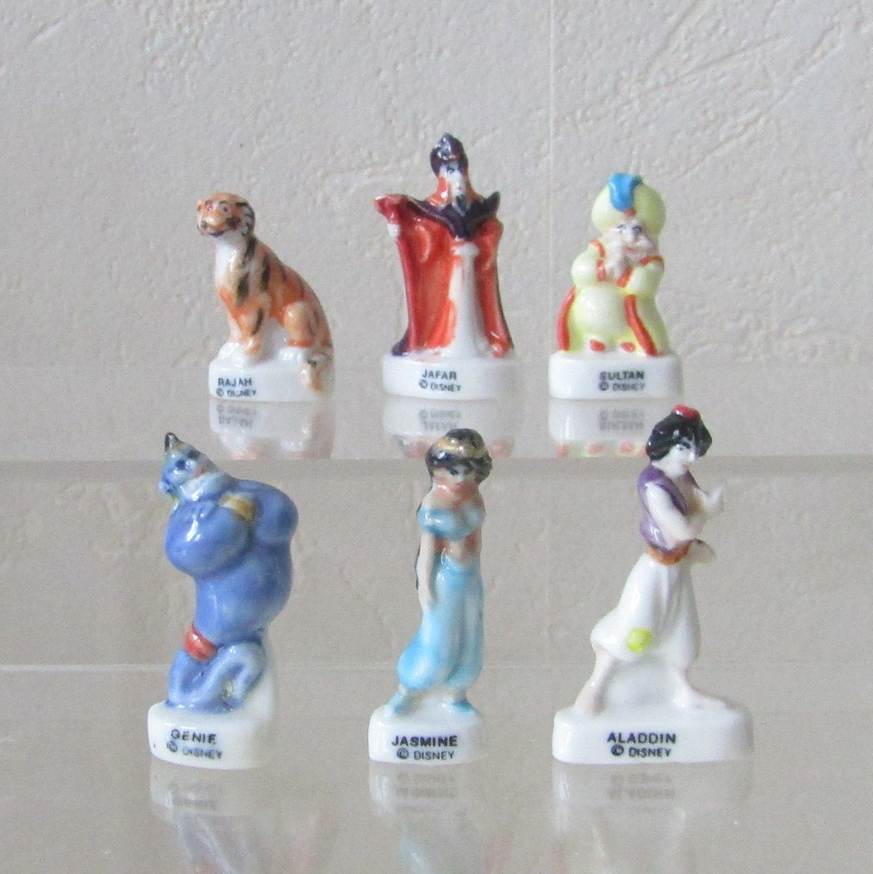 Série de 6 fèves brillantes en porcelaine Aladdin (Éditions Arguydal, 1994) représentant Jasmine, Aladdin, Rajah, Jafar