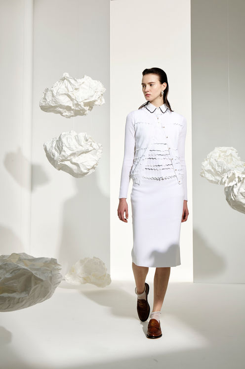 Women in white cardigan with matching colors top and skirt