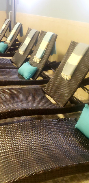 Relaxing spa lounge chairs with teal pillows