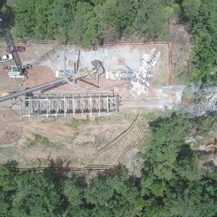 Aerial view of a large construction site with crane and bridge work.