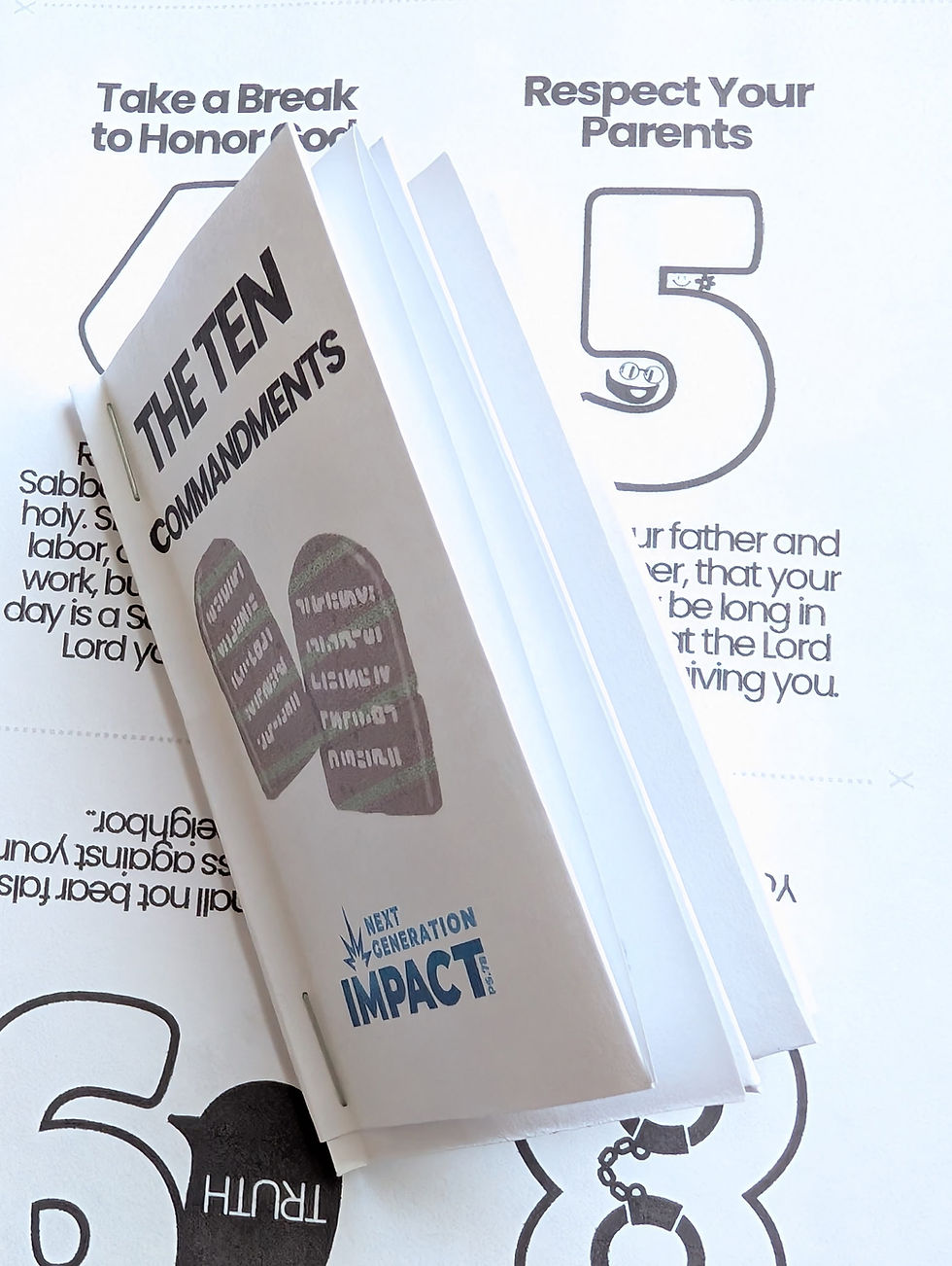 Thumbnail: View of the Ten Commandments booklet on top of one of the flat printed sheets