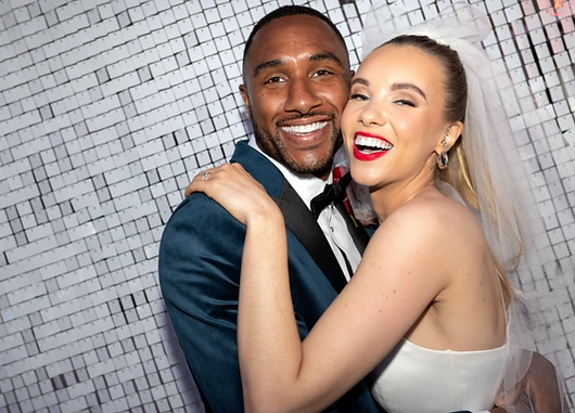 Bride and Groom show off their big smiles in selfie photo booth with silver sequin backdrop