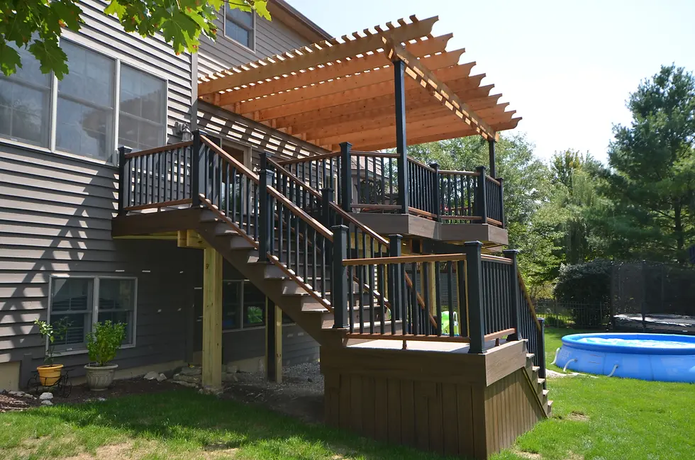 Cedar pergola attached to house on top of a Trex composite deck with matching two-tone colors.