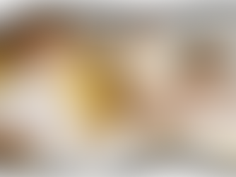 Three people sitting cross-legged on a yellow couch meditating, with calm expressions and fingers in a mudra position, in a neutral-toned room.