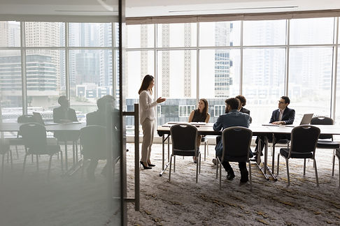 Wide shot of multiethnic business team talking at meeting table in office conference room,