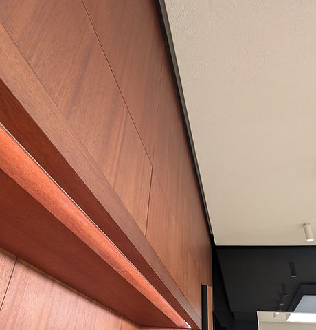 Close-up of wood wall panelling with a lit recessed ledge