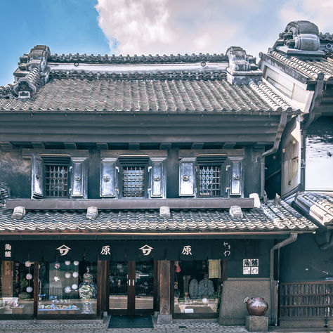 Traditional kurazukuri warehouse-style shopfront in Kawagoe, Japan, with tiled roofs and black-and-white Edo-era architecture under a blue sky
