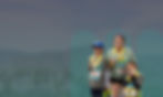 Woman and her children finishing a race and wearing medals. The people are set on a background of th