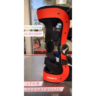 An orange and black knee orthosis