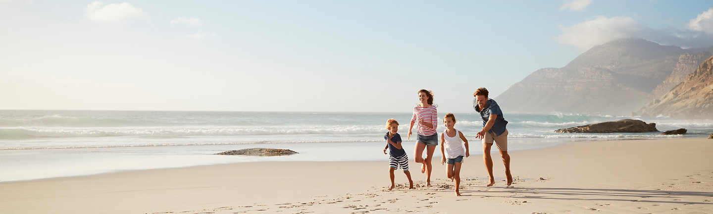 parents-running-along-beach-with-children-summer-vacation.jpg