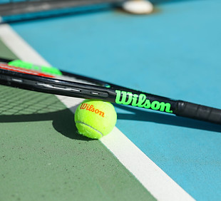 raquette de tennis wilson avec terrain bleu et balle de tennis