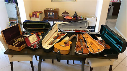 table full of instruments (cornet, violins, clarinet, small guitar)