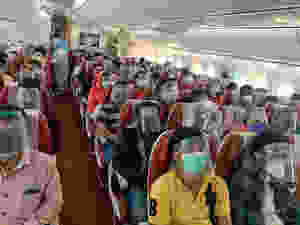 people in a flight with face masks and shields and crew in PPC