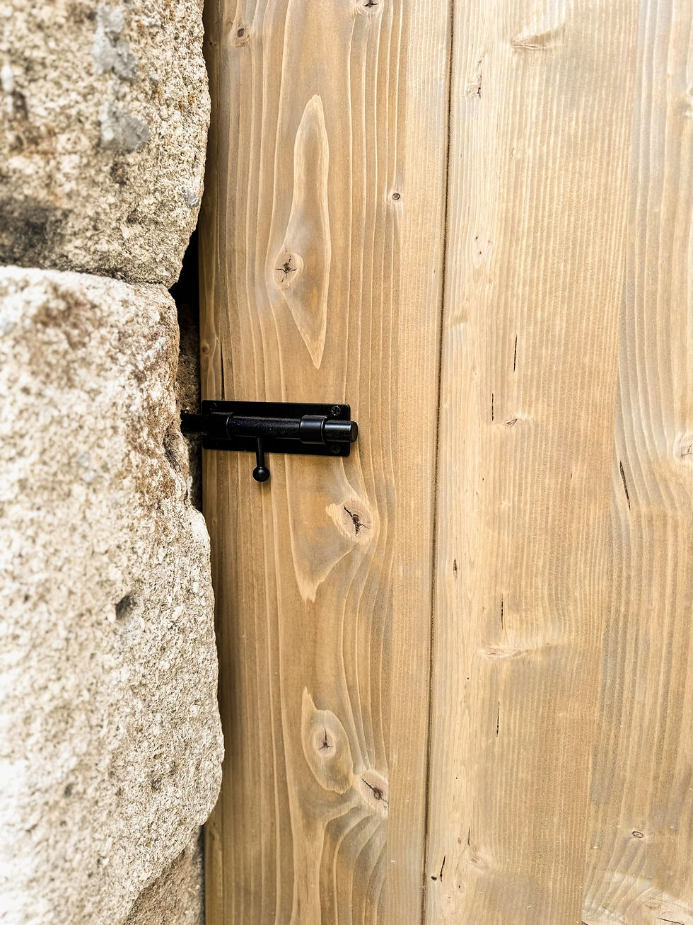 Miniature : Porte en bois massif sur mesure réalisée artisanalement, avec ferrures noires de style traditionnel, intégrée dans un encadre