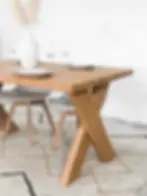 TABLE À MANGER EN DOUGLAS MASSIF AVEC PIÈTEMENT EN CROIX DANS UN INTÉRIEUR MODERNE ET ÉPURÉ.