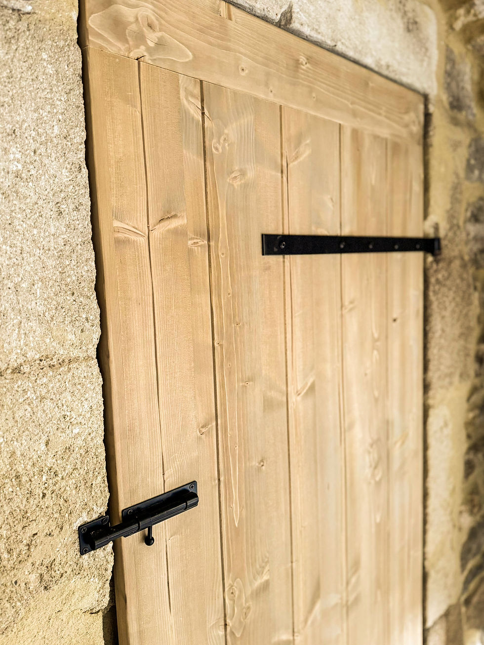 Miniature : Porte en bois massif sur mesure réalisée artisanalement, avec ferrures noires de style traditionnel, intégrée dans un encadre