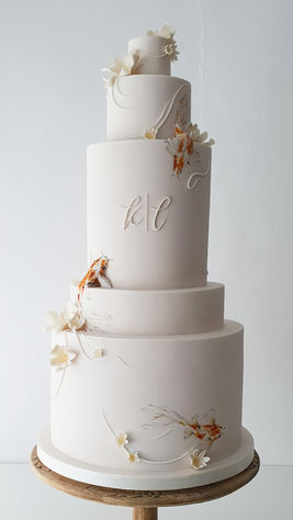 5-tier fondant wedding cake adorned with sugar flowers, accent lines, and hand-painted koi fish, exuding graceful, timeless elegance.