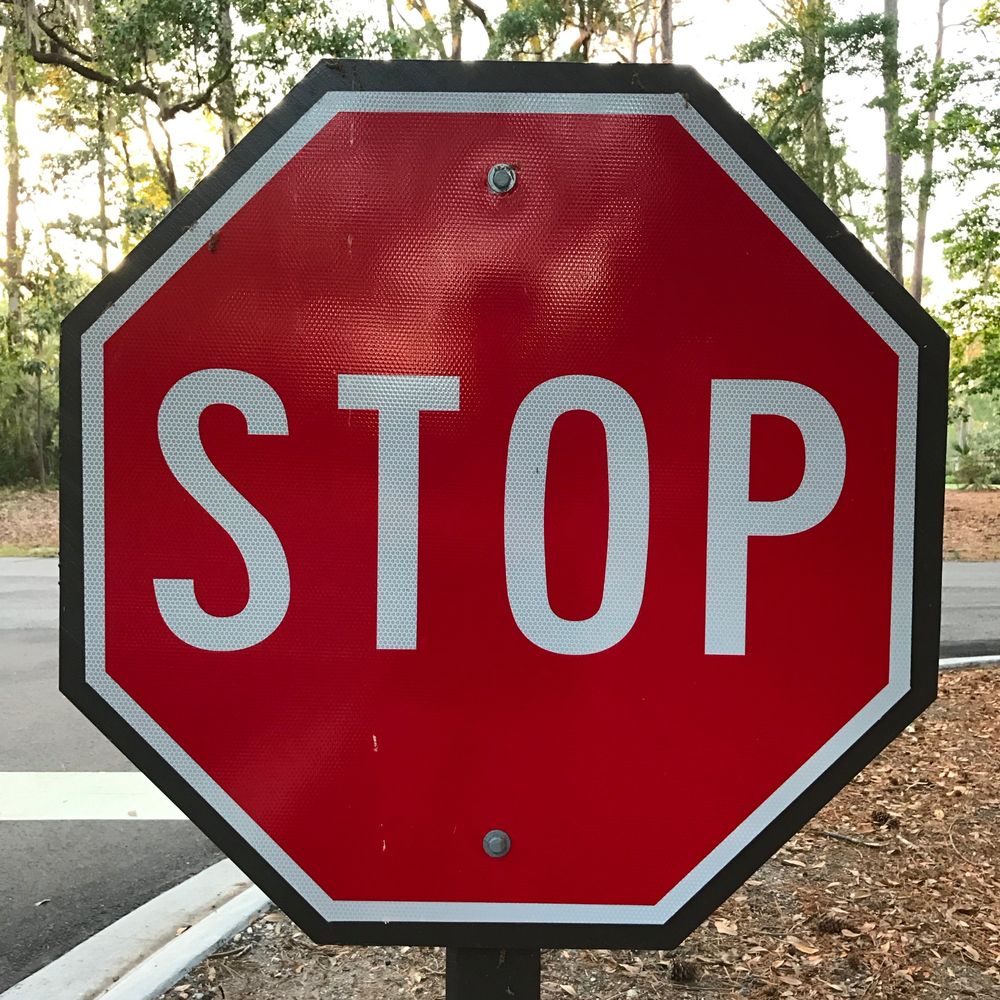 A red stop sign at the side of a road