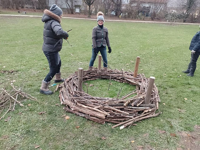 Freiwillige Helfer beim Bau des Adventkranzes aus Naturmaterialien