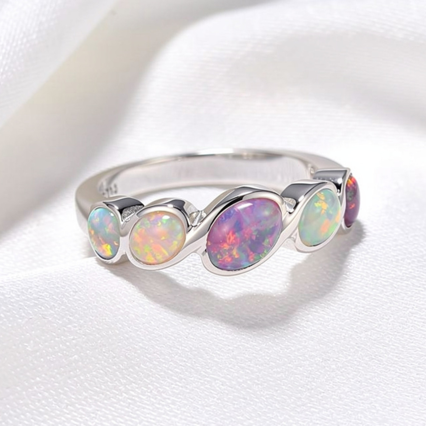 Delicate ring featuring five opal stones with compartment settings.