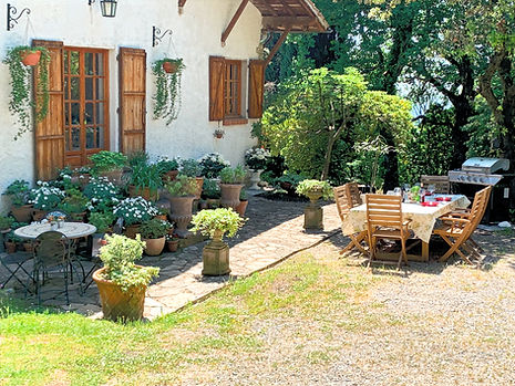 Una casa tradicional toscana con fachada de piedra, tejas de terracota y contraventanas de madera, rodeada de