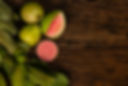 Fresh red guavas with green leaves on wooden demolition background. Wood texture and guava