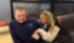 A male service user and female Lotus support worker giggling together