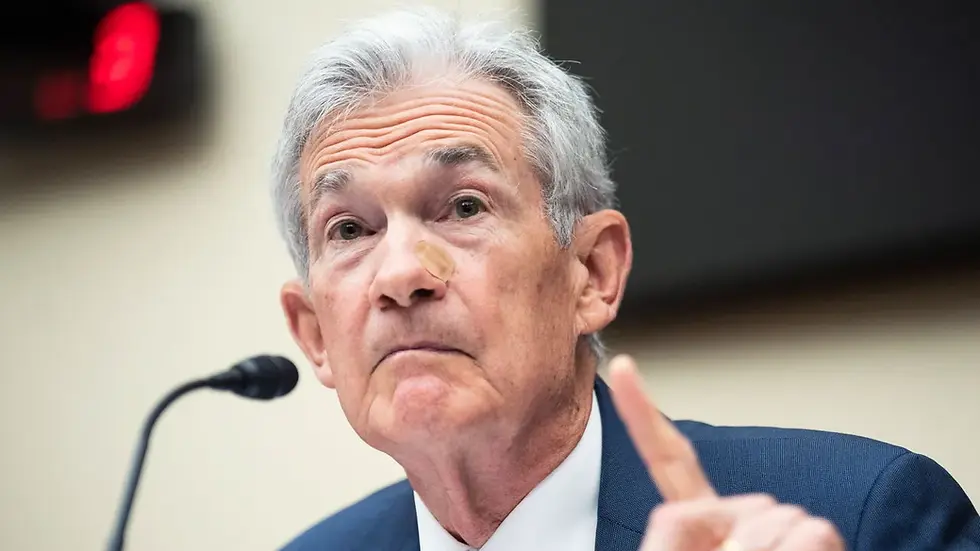 Federal Reserve Chair Jerome Powell speaking at a press conference, emphasizing a wait-and-see approach to interest rates.