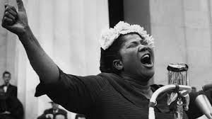 Mahalia Jackson performing passionately into a microphone, capturing her iconic gospel voice and presence during the Civil Rights era.