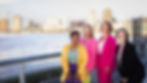 Cool Murphy Real Estate team at a New Orleans wharf, with skyline in the background — includes a new generation of transplants helping others find home.