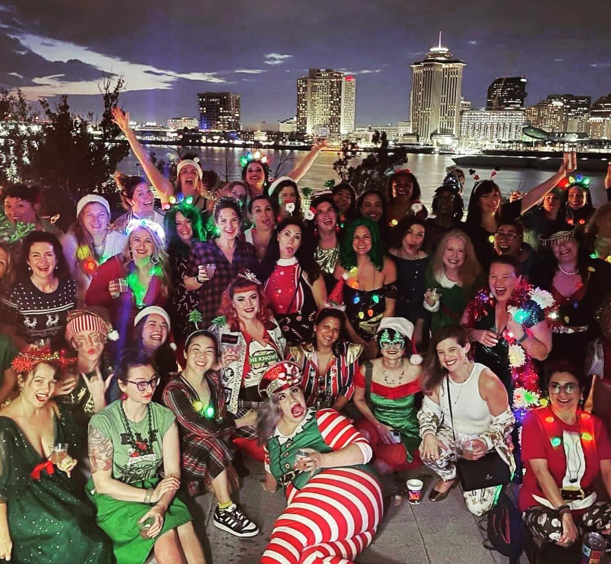 Darcie Braai with members of the Real Housewives of Algiers Point community group, posing in front of historic doors.