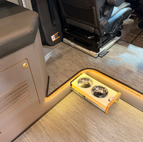 Elevated floor in Sprinter with hidden dog bowls.