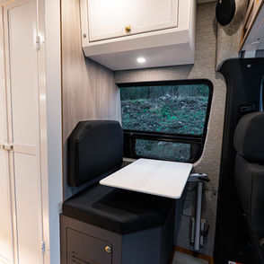 Camper van dinette with black leather and white Lagun table.