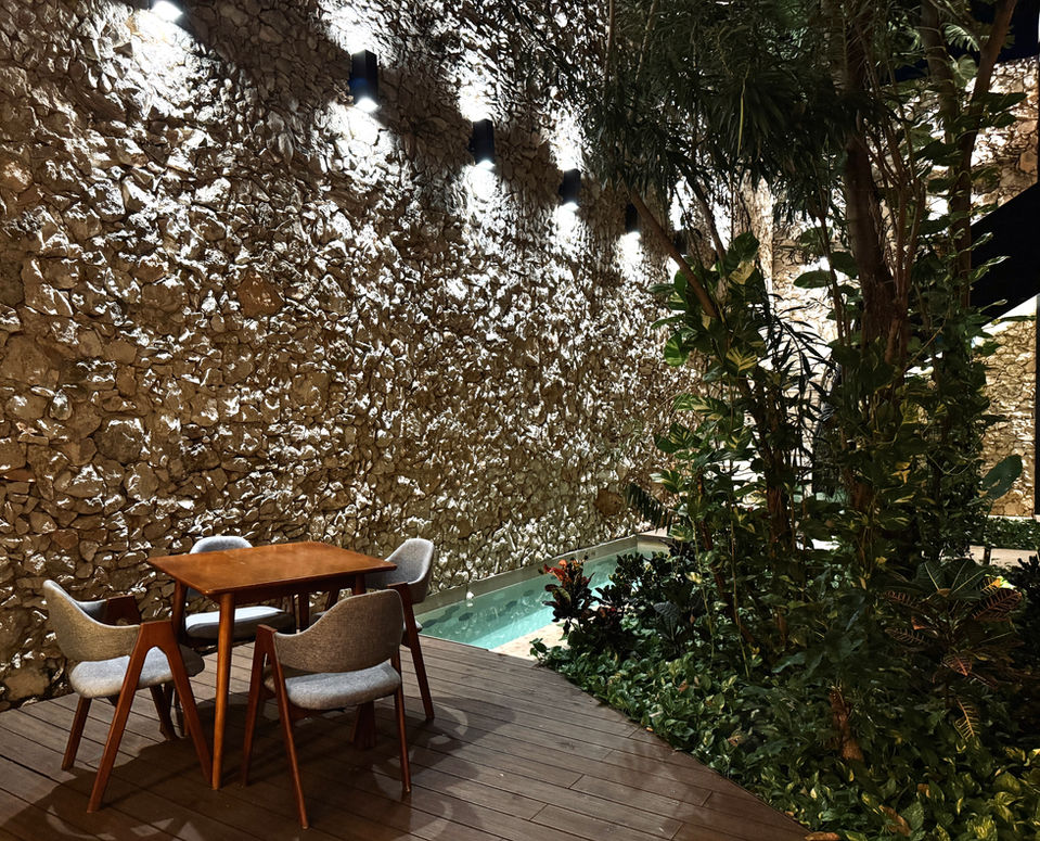 Terraza del Hotel Travertino con mesa y sillas de madera.