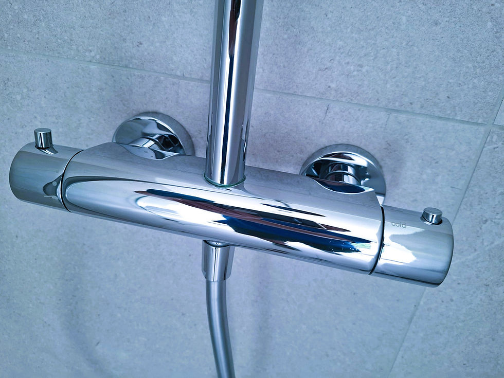 Chrome shower mixer and riser on light tile wall, with cold label visible and glossy reflections.