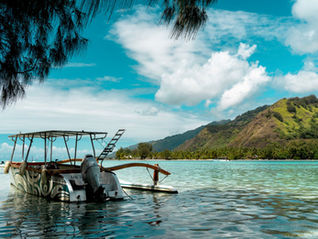 Bateau dans le lagon turquoise de Moorea, Polynesie francaise, illustrant le choix ferry ou avion pour rejoindre l'ile