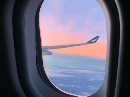 Vue d'une aile d'avion par le hublot au coucher de soleil, vol long-courrier vers Tahiti
