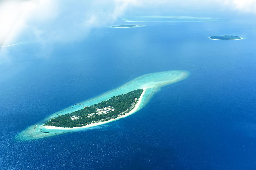 Vue aérienne d'une île polynésienne et de son lagon turquoise survolée lors d'un vol inter-îles Air Tahiti ou Air Moana