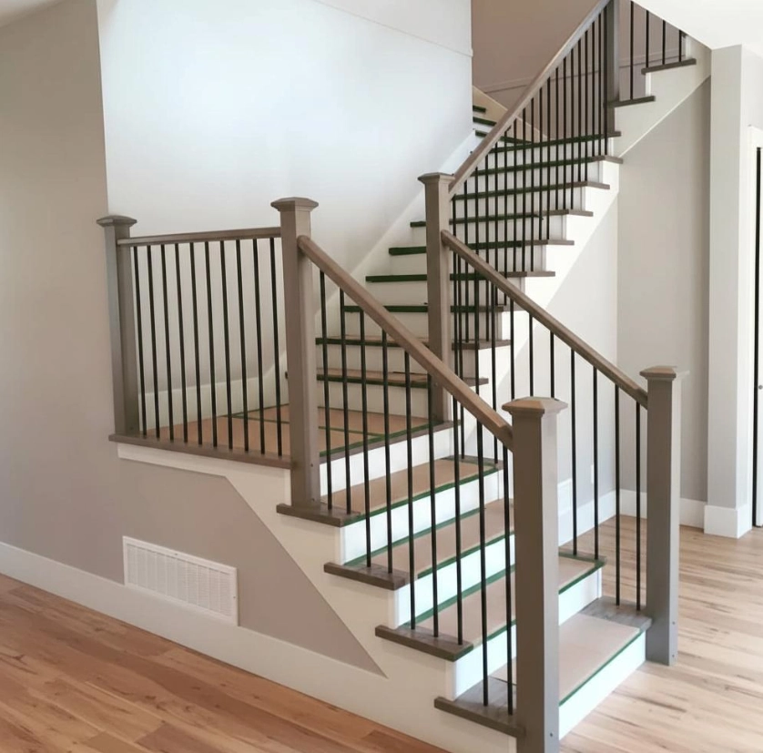L-Shaped and U-Shaped Switcback Stairs, Interior stair railings with wood handrail and black metal balusters on a split-level staircase