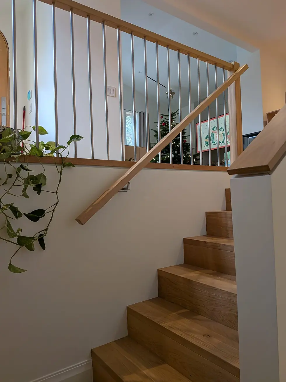 Interior stair railings with wood handrail and vertical metal balusters on a modern split-level staircase