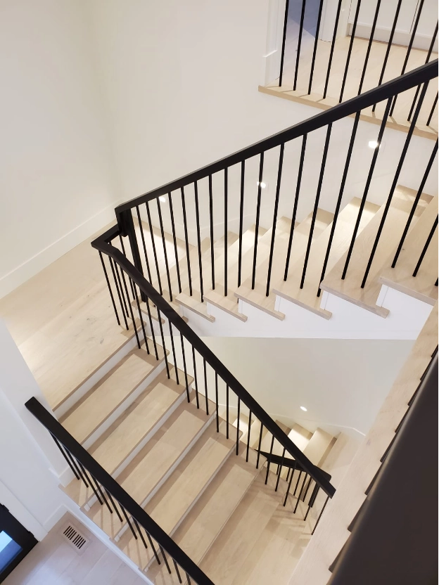 Interior stair railing with slim black spindles and pale wood treads in contemporary Vancouver home
