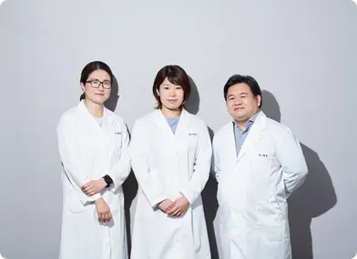 Three researchers from KINS Clinic in Singapore collaborating on innovative acne treatment methods in a laboratory setting.