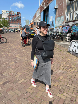 Daniella Perera smiling while holding a vintage Verkade album at NDSM in Amsterdam after visiting IJ-Hallen flea market