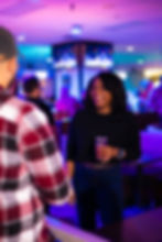 Young adult woman smiles with a cocktail in her hand at Grand Station